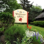 the wildflower grill sign with building on th eright